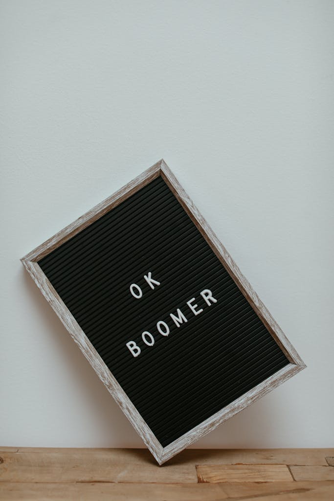 A Letter Board Leaning on a White Wall on a Wooden Surface